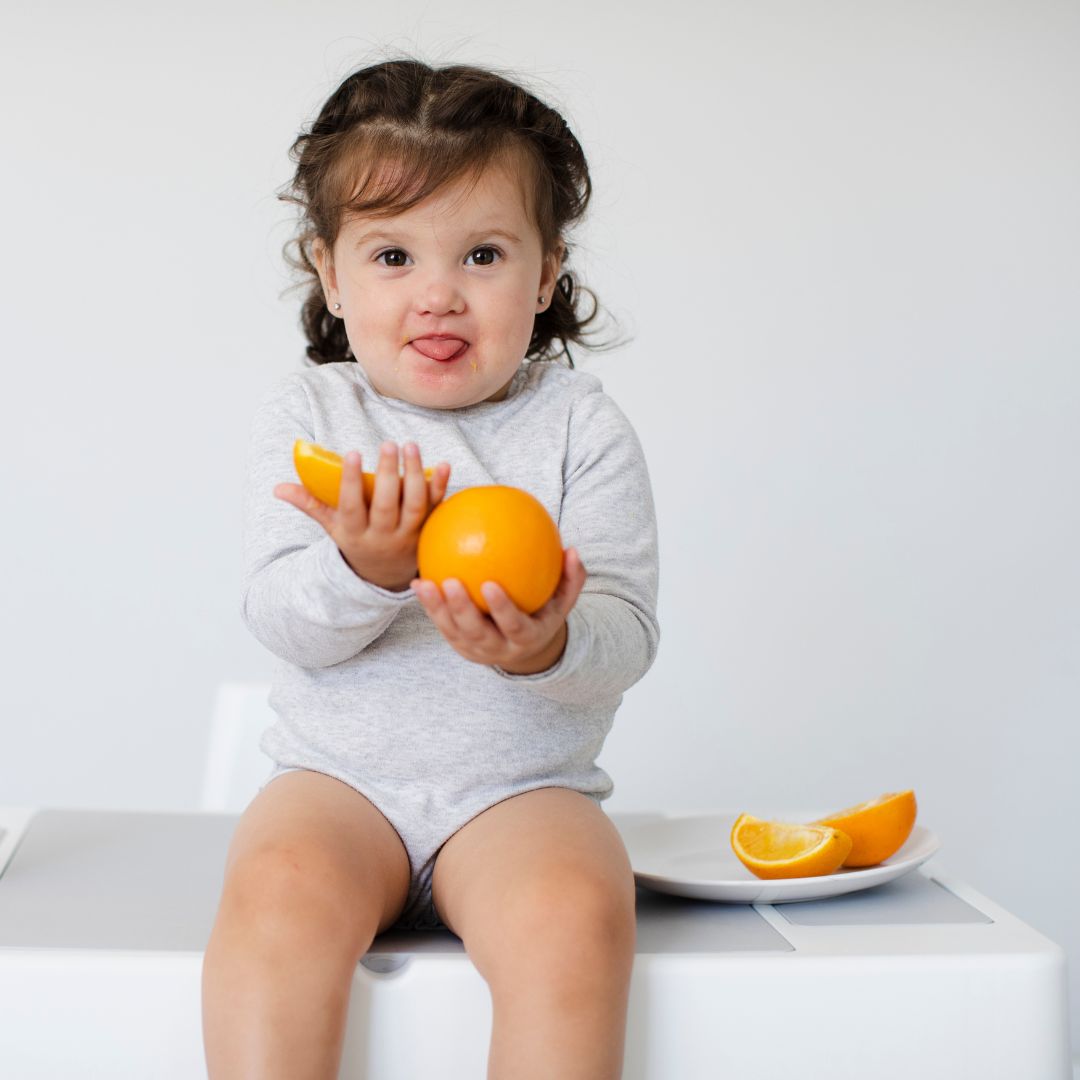 Niña comiendo naranjas